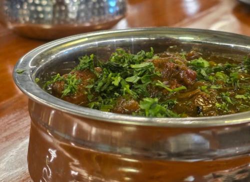 a bowl of food with meat and greens in it at The Palace by Boho Travelista in Bhīm Tāl