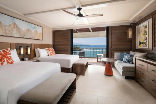 a hotel room with two beds and a balcony at Mauna Kea Beach Hotel, Autograph Collection in Hapuna Beach