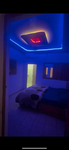 a blue room with a bed and a red light at Hotel Kamla Palace in Haridwār