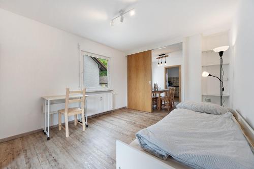 a bedroom with a bed and a desk and a table at Kleeblatt in Bad Wildbad