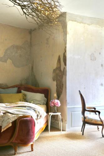 a bedroom with a bed and a chair at Chateau Chemilly in Chemilly