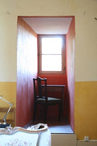 a room with a chair and a window and a desk at Chateau Chemilly in Chemilly