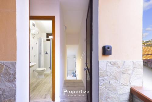 a bathroom with a toilet and a sink and a door at Il terrazzo sulla duna 5 by Propertize in Marrùbiu