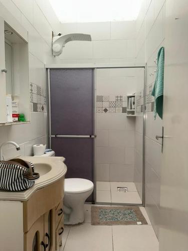 a bathroom with a shower and a toilet and a sink at Germinada in Imbé