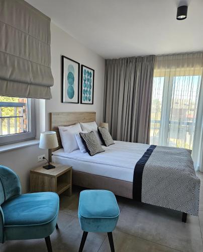 a bedroom with a large bed with a blue chair at VILLA LIPOVA STEGNA pokoje i apartamenty dedykowane osobom dorosłym in Stegna