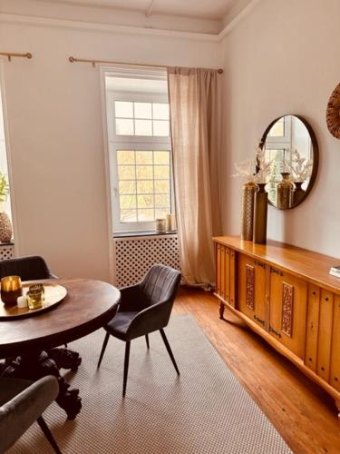 a living room with a table and a mirror at Ambiente Deluxe Schloss Falkenhorst in Kleinblittersdorf