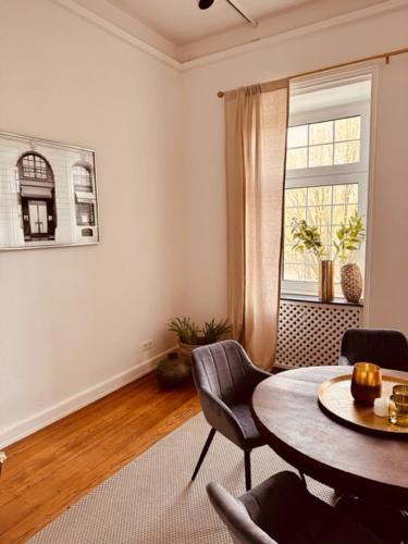 a living room with a table and chairs and a window at Ambiente Deluxe Schloss Falkenhorst in Kleinblittersdorf