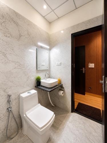 a bathroom with a white toilet and a sink at Sparkle Jaipur in Jaipur