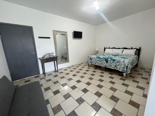 a bedroom with a bed and a tiled floor at Hotel Posada La Catrina in Ciudad Fernández