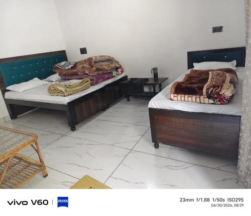 two beds are sitting in a room with at Shaaneshwar Mahadev Hotel & Restaurant in Phata