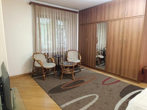 a living room with chairs and a table and cabinets at Benefice Apart in Yerevan