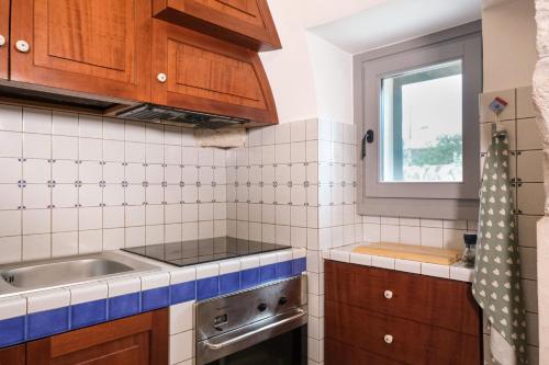 a small kitchen with a sink and a window at Pavì Trulli e Suites in Locorotondo