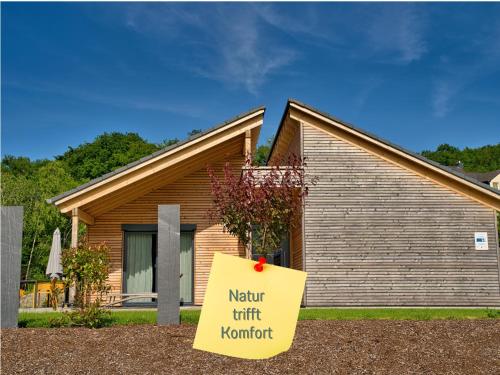 ein Haus mit einem Schild davor in der Unterkunft Traumweiler Ferienhäuser am Nationalpark Hunsrück Hochwald - barriearm - mit effektiver Kühlung in Kirschweiler