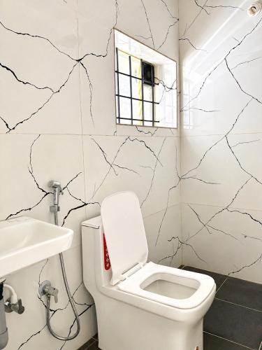 a bathroom with a toilet and a sink at Classic Comfort in Chikmagalūr