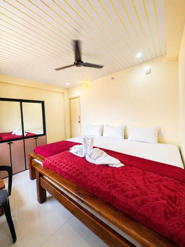 a bedroom with a bed with red sheets and a ceiling at Classic Comfort in Chikmagalūr