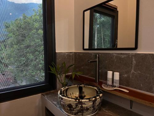 a bathroom with a sink and a large window at Valley Villa Hotel in Nongkhiaw