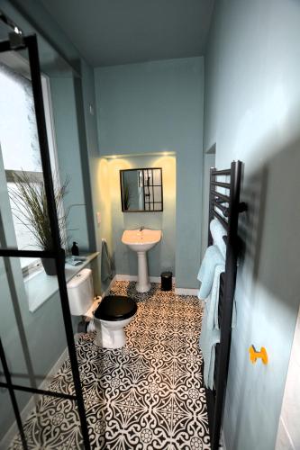 a bathroom with a toilet and a sink and a tub at Crescent House in Plymouth