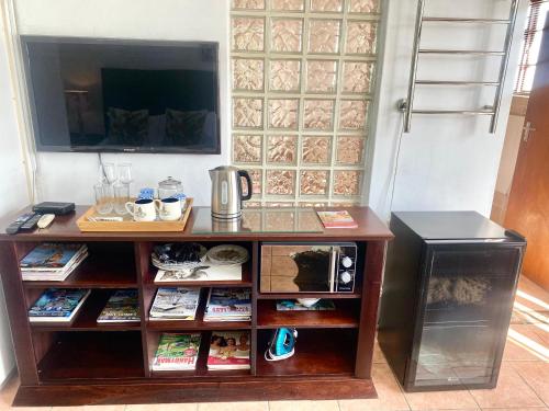 a wooden entertainment center with a tv on top at Franschhoek Mountain Escape in Franschhoek