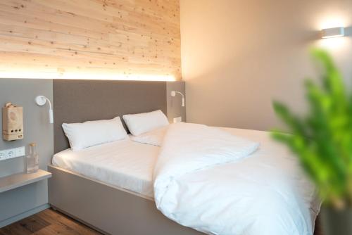 a bed with white sheets and pillows on it at RELAXANS Hotel in Dinkelsbühl
