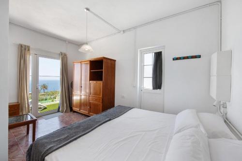 a white bedroom with a large bed and a window at vv Rincón Solaris in Tijarafe