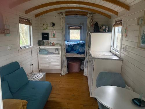 a small kitchen and living room in a tiny house at Pipowagen Utewyn in Reitsum