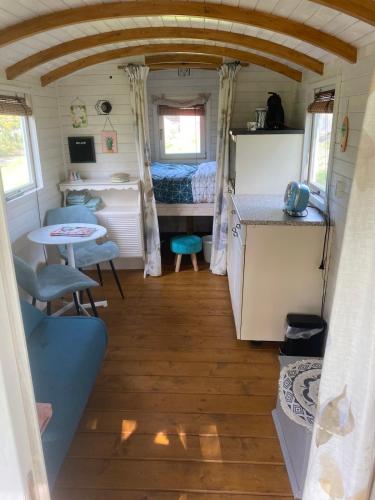 a small kitchen and a bedroom in a tiny house at Pipowagen Utewyn in Reitsum