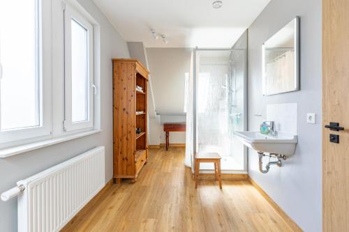 a bathroom with a sink and a wooden floor at Fischers Huus in Husum