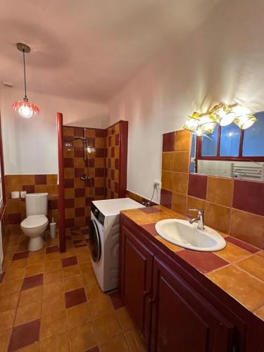 a bathroom with a sink and a washing machine at Another World Village house in Buis-les-Baronnies
