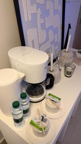 a counter with a mixer and plates on it at AURA Stay in Dammam
