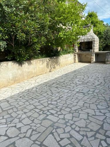 a cobblestone driveway with a stone fireplace in a yard at Apartments & Room MaDi in Senj