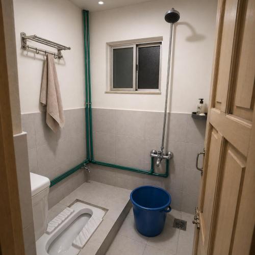 a bathroom with a toilet and a bucket in it at Highlander inn Skardu in Skardu