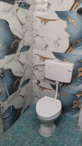 two pictures of a bathroom with a toilet and a wall at SIU Elite INN in Chennai
