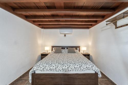 a bedroom with a bed and two lamps on two tables at vv Casa Rural El Pajar in El Pinar del Hierro