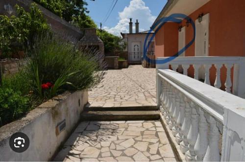 a stone walkway next to a house with a fence at Apartments & Room MaDi in Senj