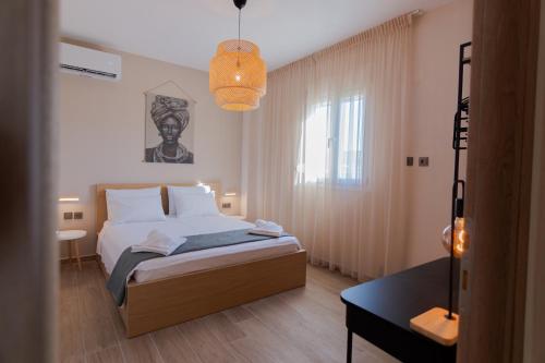 a bedroom with a bed and a pendant light at La Marine Apartments in Kalandra