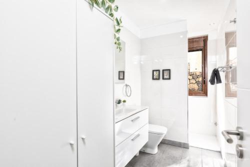 a white bathroom with a toilet and a shower at vv Cerca Nueva in Las Manchas