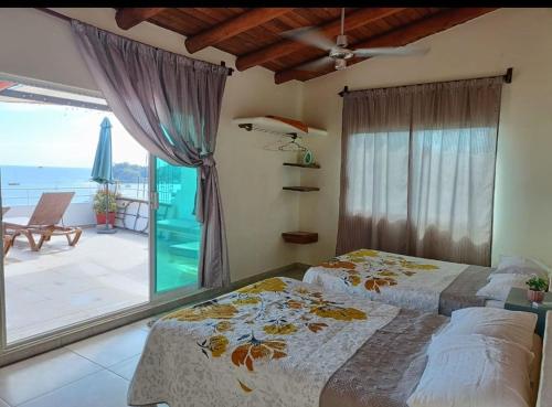 a bedroom with two beds and a view of the ocean at la vista the view in Zihuatanejo