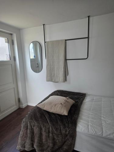 a bedroom with a bed with a blanket and a mirror at Eric the Red Guesthouse in Reykjavík