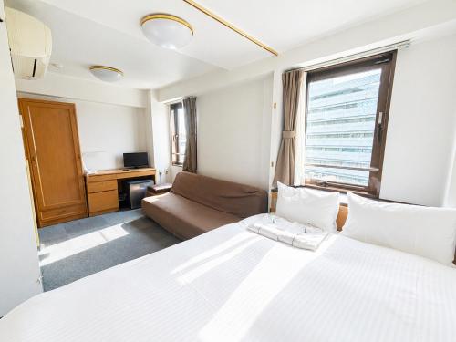 a hotel room with a bed and a couch at Sakura Hotel Hatagaya in Tokyo