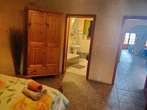 a bedroom with a bed and a bathroom with a tub at Ta' Karkar Villa Bed and Breakfast in Xagħra
