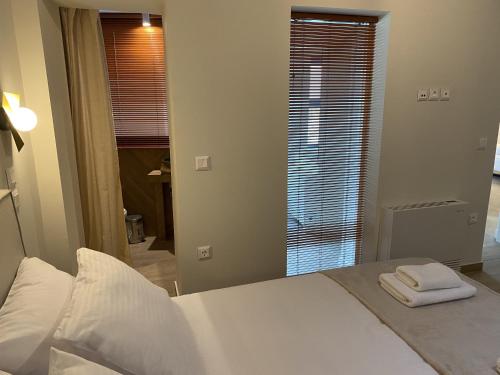 a bedroom with a bed with two towels on it at Hercules Historic Apartments in Chalkida