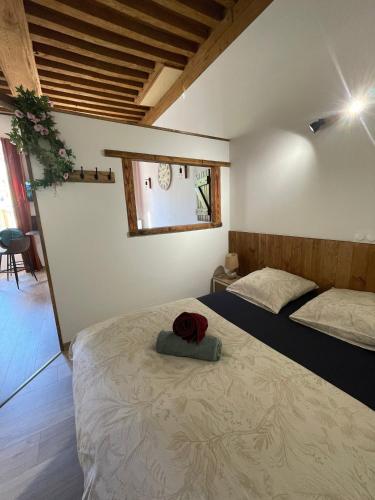 a bedroom with a bed with a red hat on it at Studio cosy -Hyper centre -Tout à pied in Paray-le-Monial