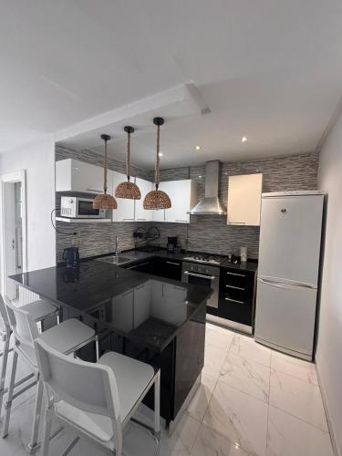a kitchen with a black counter and a white refrigerator at Perle Verte de Gammarth in Tunis