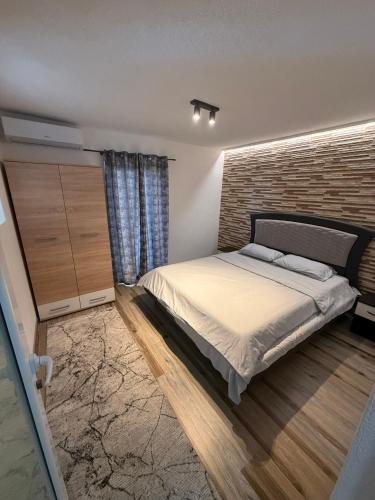 a bedroom with a bed and a brick wall at Baywatch Apartmans in Brca