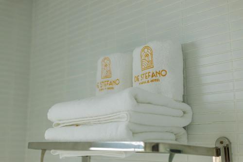 a pile of towels on a table in a bathroom at De Stefano Coffee and Hotel in Phú Quốc
