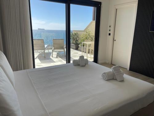 a bedroom with a large bed with two towels on it at R Lapsi Guesthouse in Siġġiewi
