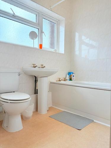 a bathroom with a toilet and a sink and a tub at Two Floor Flat in Town Center in Kenilworth