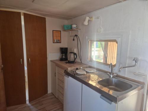 a small kitchen with a sink and a window at Mobilheim am Hafen in Gager