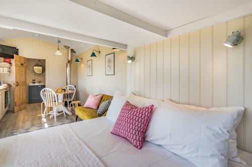 a bedroom with a white bed with pink pillows at Bankhead Shepherds Hut in Stirling