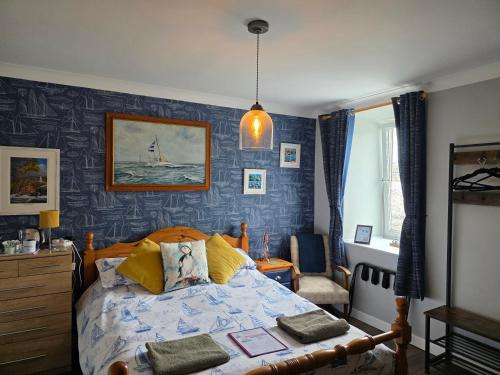 a bedroom with a bed with a blue wall at The Seafront Inn Holyhead in Holyhead